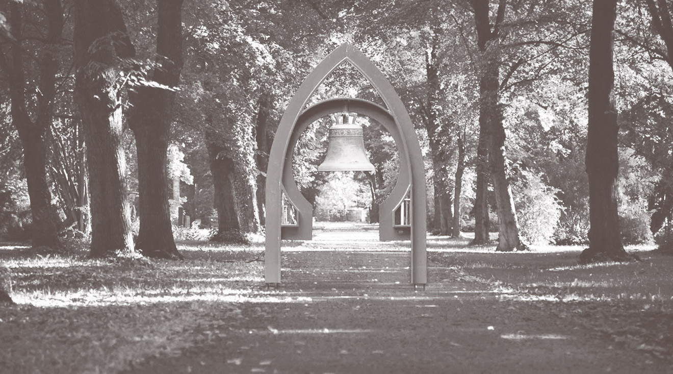 Torbogen mit Glocke auf dem Städtischen Friedhof in Leipzig. Der Bogen entspricht von der Form her dem Logo der Städtisches Bestattungswesen Leipzig GmbH